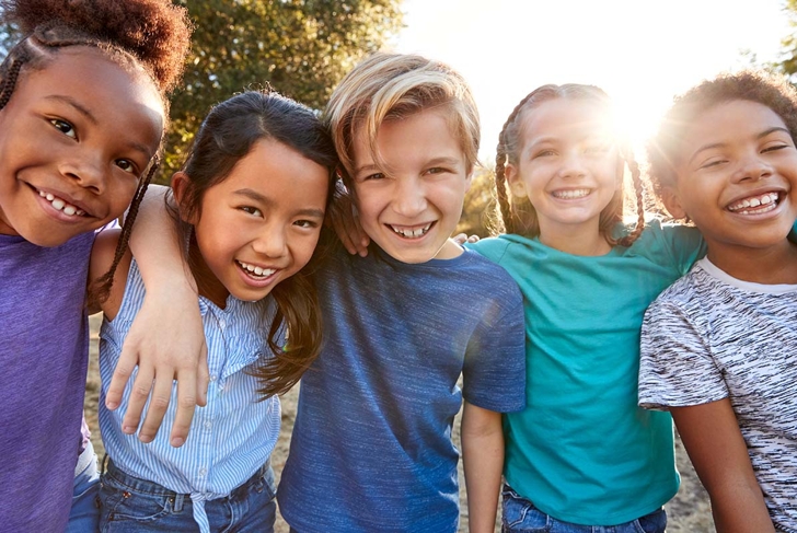 Portrait Of Multi-Cultural Children Hanging Out With Friends In Countryside Together