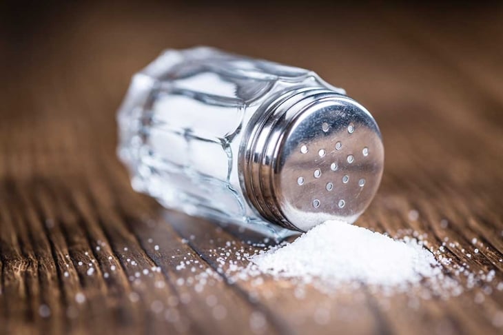 Old wooden table with a Salt Shaker (close-up shot; selective focus)